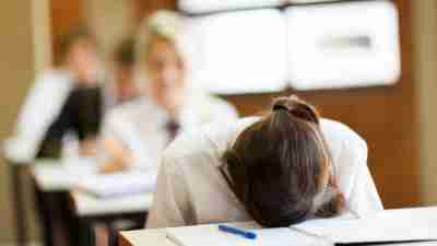 A frustrated student puts her head down and refuses help for executive function disorder.
