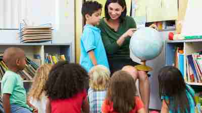 A teacher giving an attention grabbing presentation, a good strategy to improve classroom behavior.
