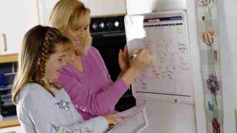 An ADHD mom and her child use a calendar to stay organized.