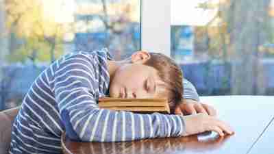 Boy with ADHD asleep on book