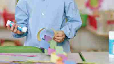 A child with ADHD doing crafts after being motivated by his teacher to try in class