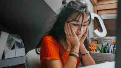 female teenager feeling stressed studing at home.E learning.Home schooling