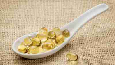 Spoon filled with fish oil capsules on burlap tablecloth, a good source of Omega 3 for people with ADHD