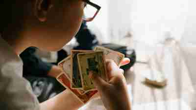 A close-up photo of a boy holding a few playing cards. Special interests take on many forms for autistic individuals.