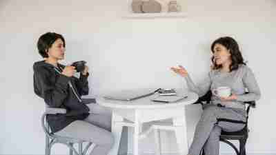 A picture of two women having a conversation about ADHD and oversharing over coffee.