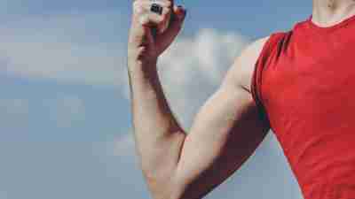 Image of a man's curled bicep, communicating strength courtesy of testosterone.