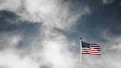 The American flag waving on a cloudy day. DEI military initiatives hold us accountable to our shared values, regardless of race, ethnicity, or ability.