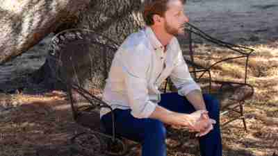 A man sits under a tree, demonstrating the benefits of nature therapy for ADHD.