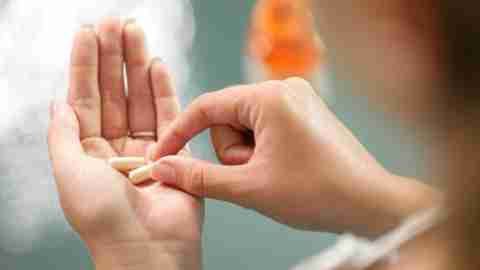 Woman with ADHD holding ritalin pills in palm
